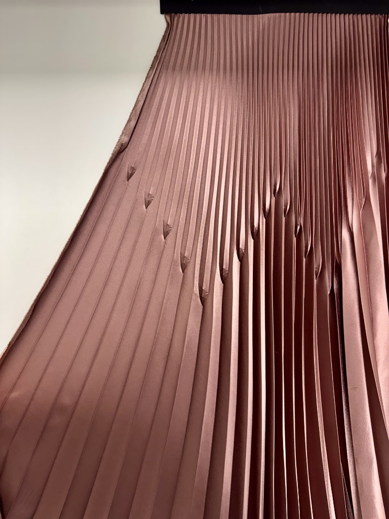 Plissé speciale su tessuto rosa con pieghe verticali scultoree con effetto appuntito