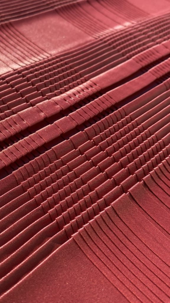 Plissé piatto rosa con dettaglio frangiato, lavorazione artigianale tessuto moda