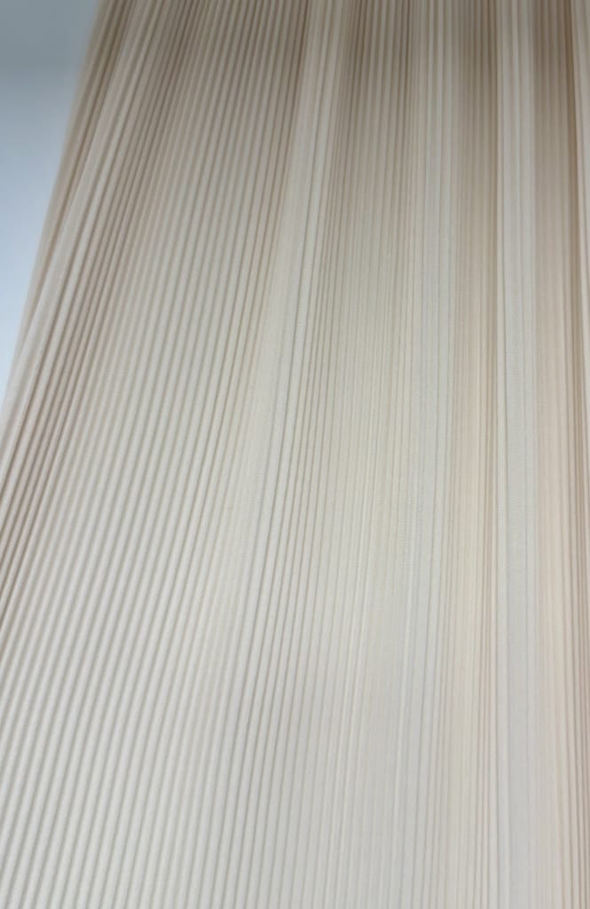 Plissé organetto su tessuto strutturato beige con pieghe orizzontali fitte per creare texture compatta