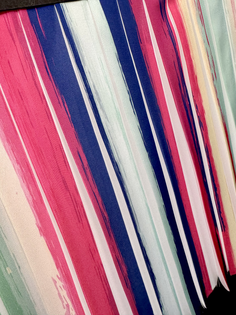 Stampa sublimatica a righe multicolore su plissé piatto verticale, effetto cromatico 