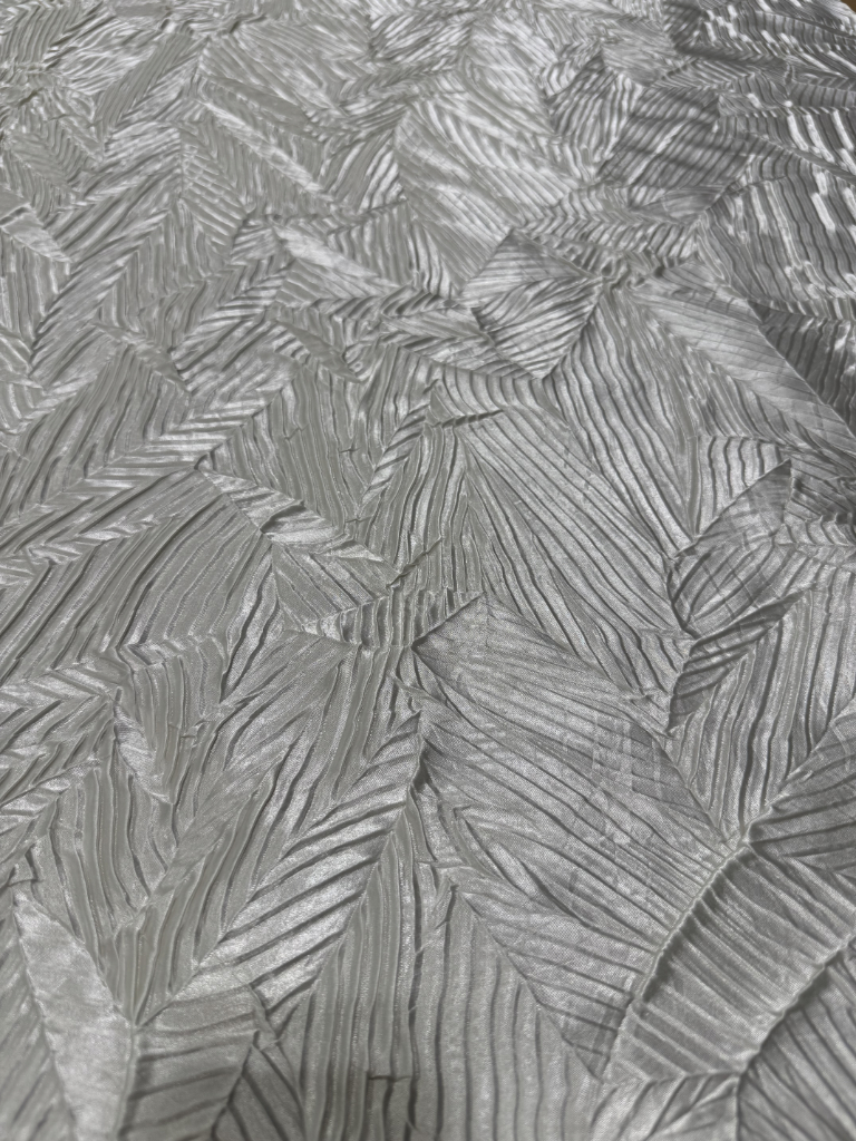 Stropicciatura tessuto grigio con pattern organico a ventaglio, lavorazione artigianale su misura