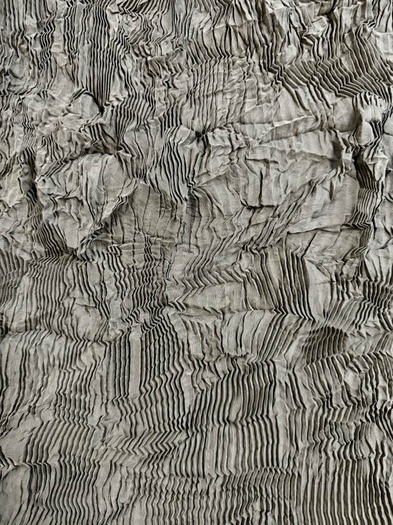 Stropicciatura artigianale su tessuto grigio con effetto corteccia/roccia, texture irregolare 
